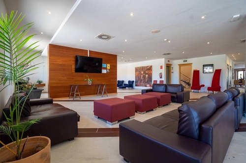 uma sala de estar cheia de sofás e cadeiras