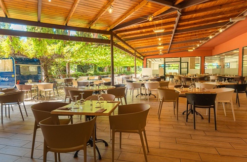 Restaurante ao ar livre do Hotel Vila Romana perto de PortAventura com mesas e cadeiras.