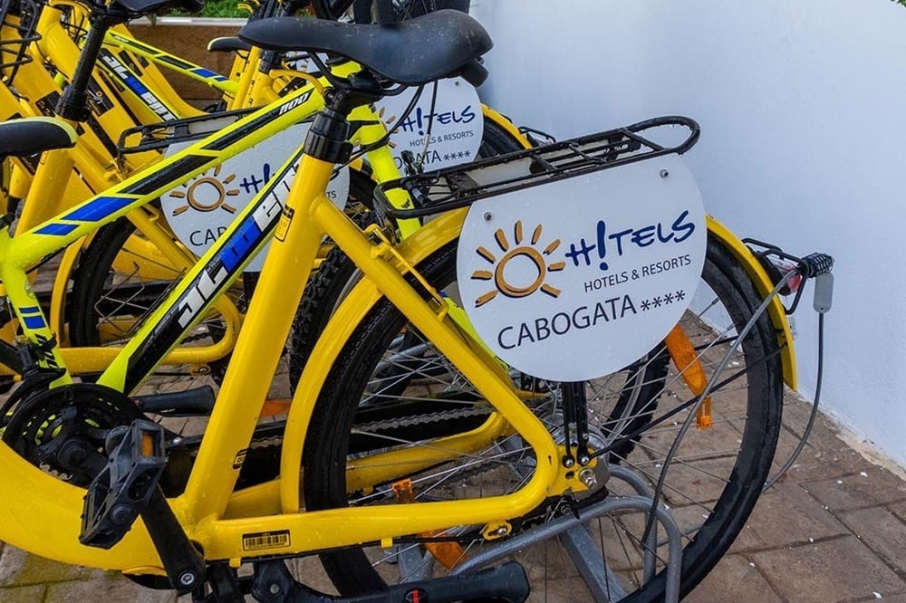 a row of yellow bicycles with a sign on the back that says 