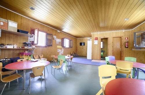 Sala infantil del Hotel Ohtels Les Oliveres: mesas y sillas coloridas.
