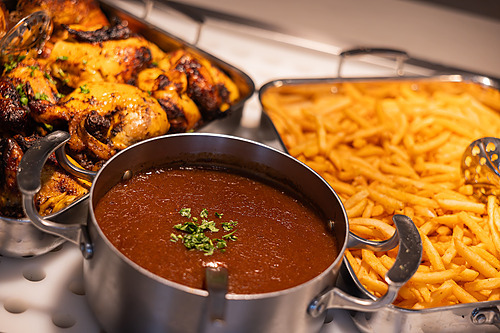 Buffet de frango assado, batatas fritas e molho em um restaurante de hotel. Hotel tudo incluído em La Pineda | Ohtels La Hacienda