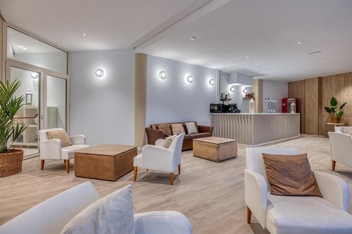 una sala de estar con sofás y sillas y una barra