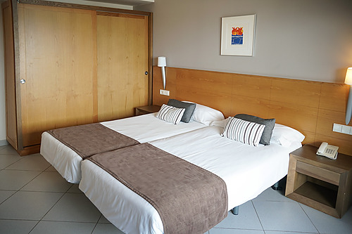 Chambre d'hôtel moderne Ohtels Campo de Gibraltar, avec deux lits, bureau et TV.