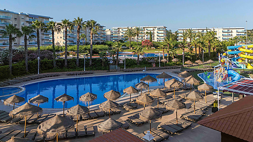 Hotel tudo incluído em La Pineda | Ohtels La Hacienda: Piscina com escorregas aquáticos, espreguiçadeiras e bungalows em resort tropical.