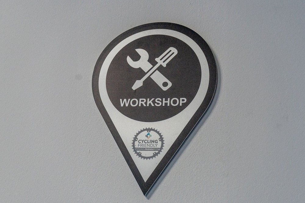 a pin with a wrench and screwdriver on it that says workshop