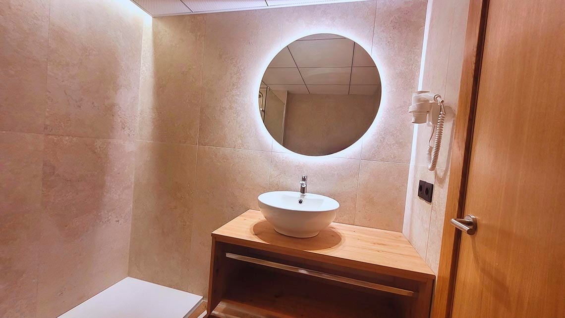 une salle de bain avec un lavabo et un miroir ovale