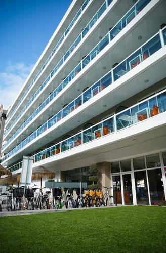 Fachada do Hotel Villa Dorada, com varandas e bicicletas no exterior.