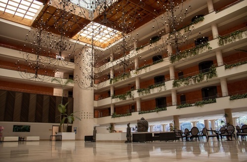 Lobby d'un hôtel tout compris avec lustres imposants et espace lounge.