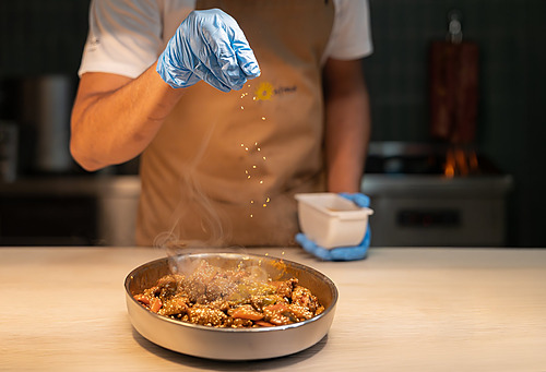 Cocinero emplatando un plato caliente en el restaurante de Ohtels Les Oliveres.