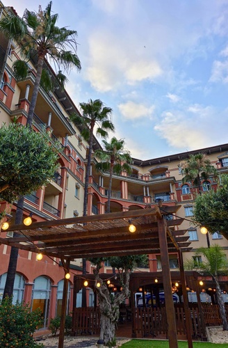 Entrée d'un hôtel tout compris à Islantilla, Huelva | Ohtels Islantilla avec palmiers et guirlandes lumineuses