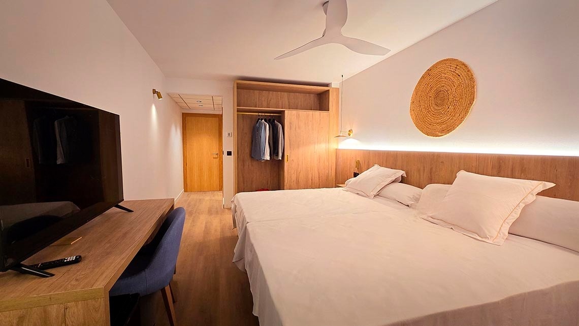 une chambre avec un lit , une télévision et un ventilateur au plafond