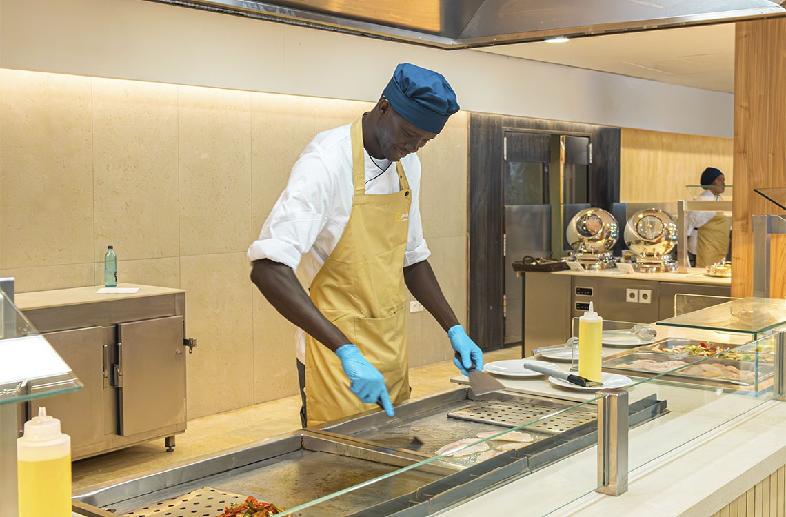 Chef en Ohtels Corporativa preparando pescado fresco en una plancha.