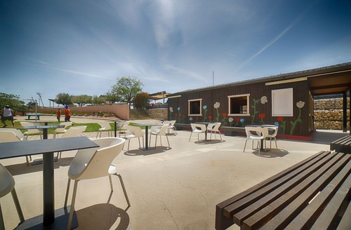 Exterior del Hotel Ohtels Les Oliveres en el Delta del Ebro con mesas y sillas al aire libre.