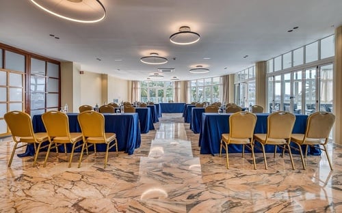 una sala de conferencias con mesas y sillas azules y doradas