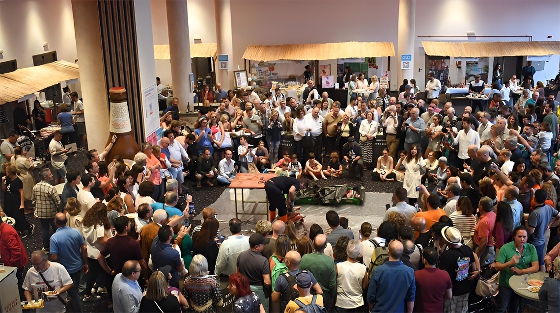 L'image représente l'entrée moderne du Gran Hotel Almeria, avec sa façade en carrelage gris, des portes vitrées et des plantes en pot de chaque côté.