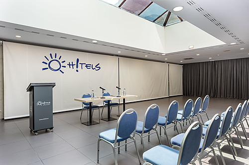 une salle de conférence avec des chaises bleues et un projecteur