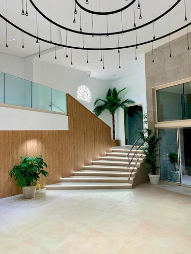 un pasillo con escaleras y plantas y un sol en el techo