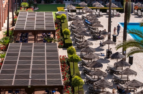 Hôtel tout compris Ohtels Islantilla, Huelva : piscine, parasols, terrasses et jardins fleuris.