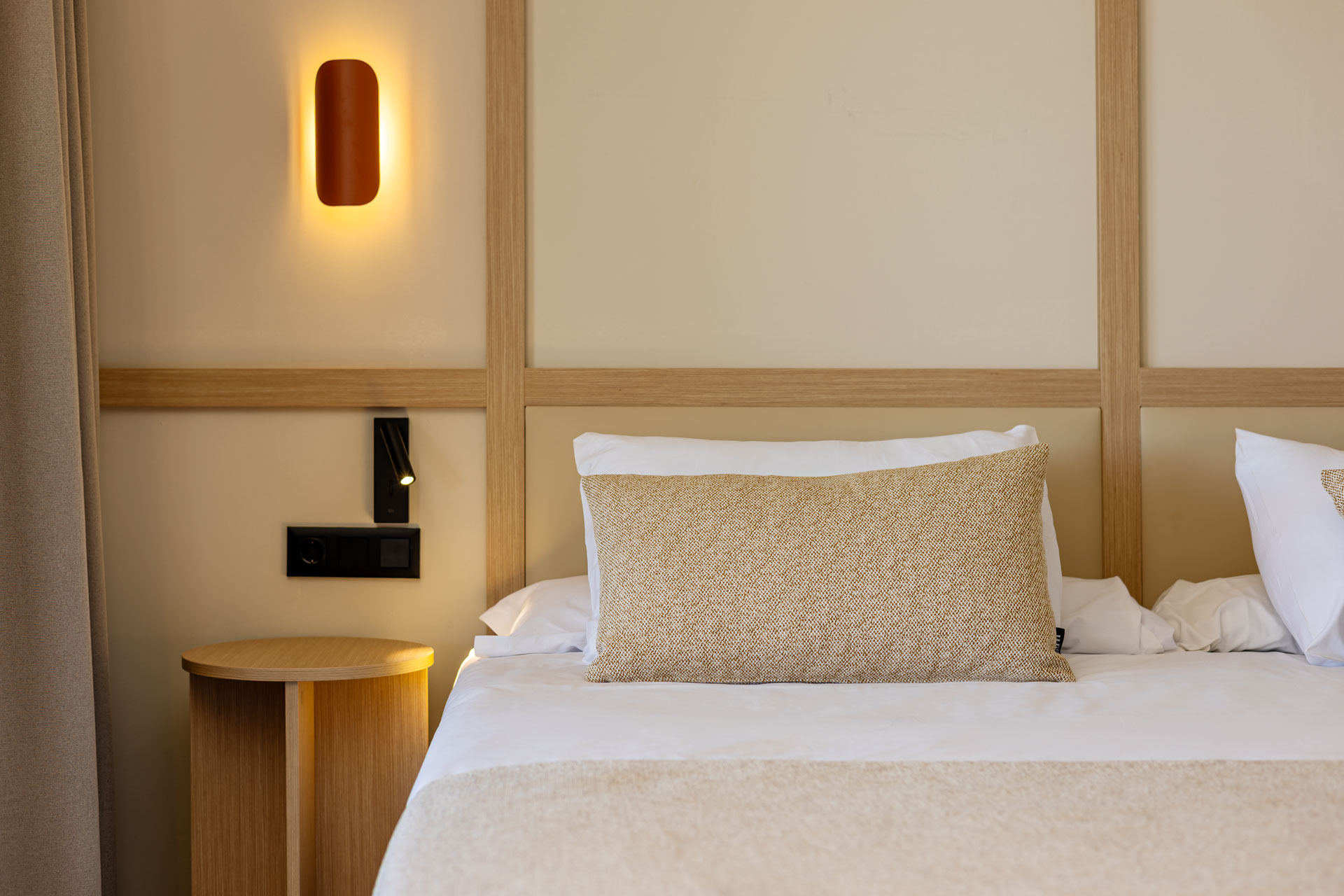 Lit candle and books at Ohtels: Corporativa, creating a cozy and refined hotel atmosphere.
