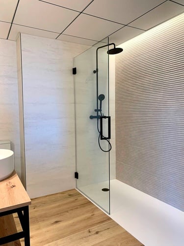 un baño con un lavabo y una ducha de vidrio