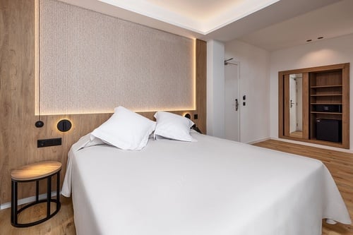 una habitación de hotel con una cama y una mesita de noche