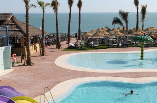 Hotel tudo incluído em Mazagón, Huelva: piscinas, palmeiras e mar.