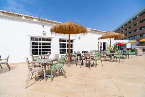 a patio area with tables and chairs and umbrellas