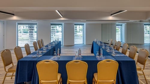 una sala de conferencias con mesas y sillas en forma de u