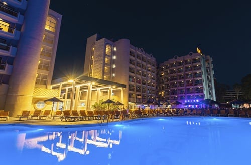 Hotel Ohtels Belvedere: Piscina y edificios iluminados de noche. Cerca de Port Aventura, Salou.