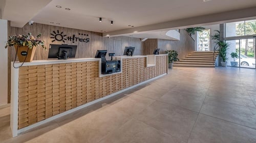 el vestíbulo de un hotel con un mostrador de recepción y escaleras