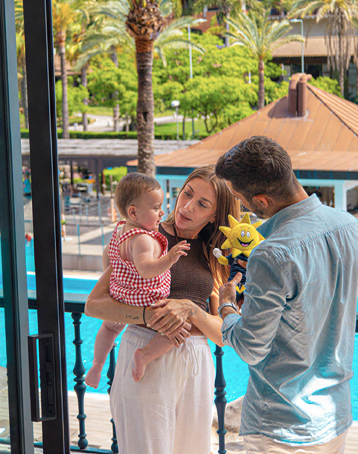 Familia feliz en balcón con piscina, ideal para Ohtels: Corporativa.