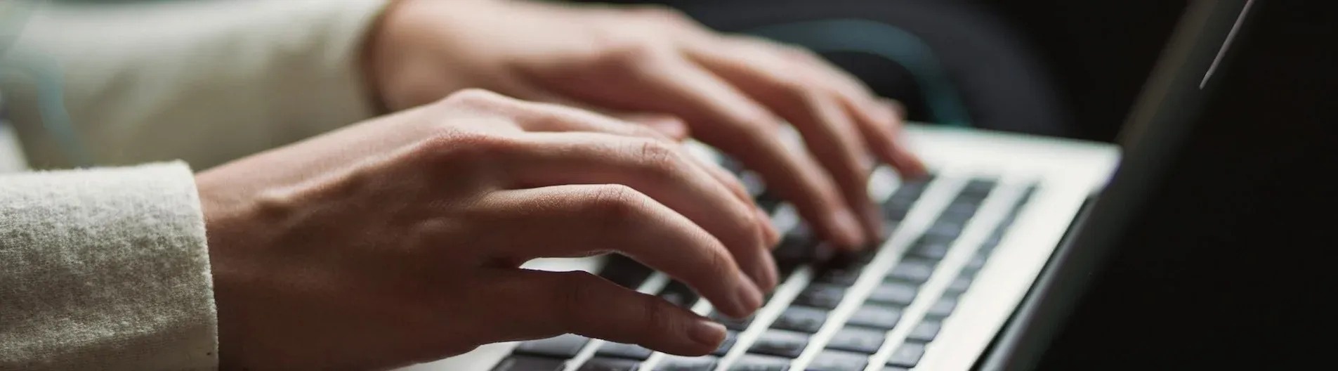 a close up of a person typing on a laptop