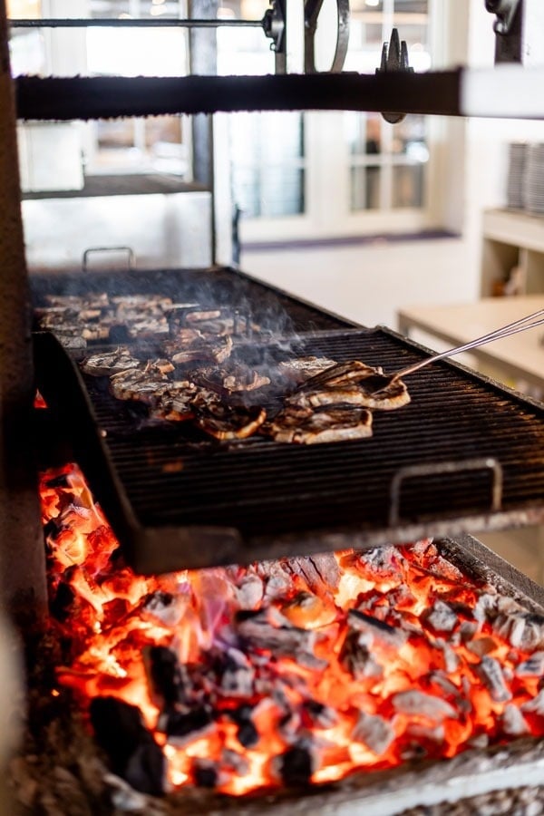 steaks are cooking on a grill over a fire