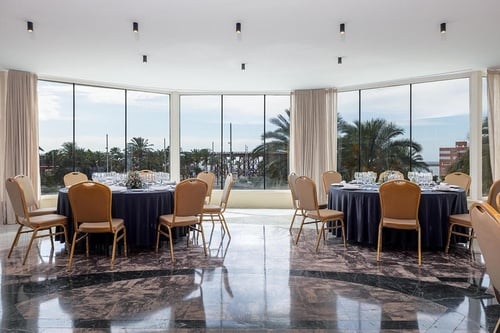 una habitación con mesas y sillas y una gran ventana