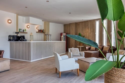 una sala de estar con sillas y mesas y un bar