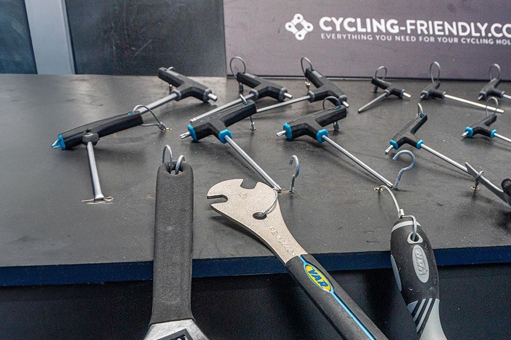 un montón de herramientas están sobre una mesa junto a un cartel que dice ciclismo-friendly.com