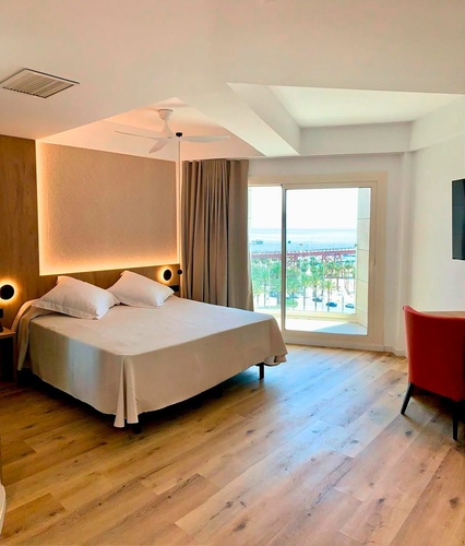 una habitación de hotel con una cama y una silla roja