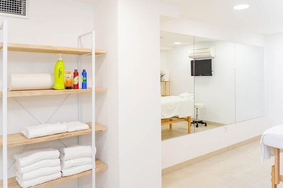 a bottle of shampoo sits on a shelf next to a stack of towels