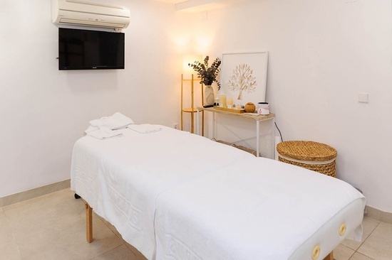 a massage table in a room with a tv above it