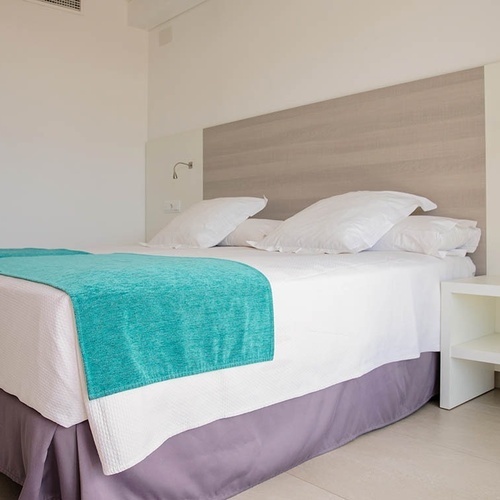 una habitación con dos camas y una mesita de noche