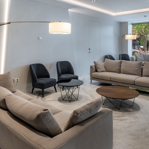 una sala de estar con sofás y sillas y una mesa de madera