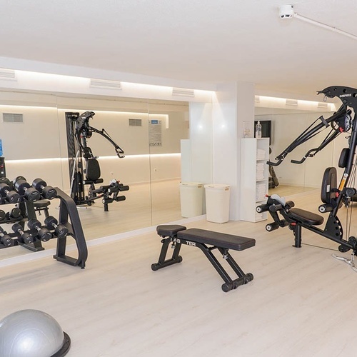 un gimnasio con pesas y una máquina de ejercicios