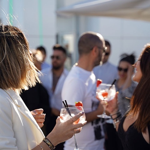 una mujer sostiene una copa de vino con una fresa encima
