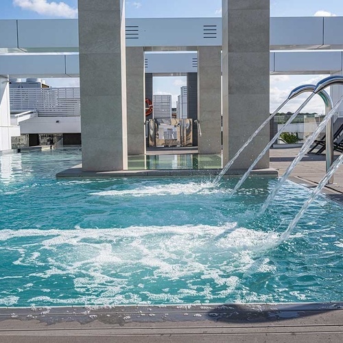 una piscina con fuentes y escaleras que conducen a ella