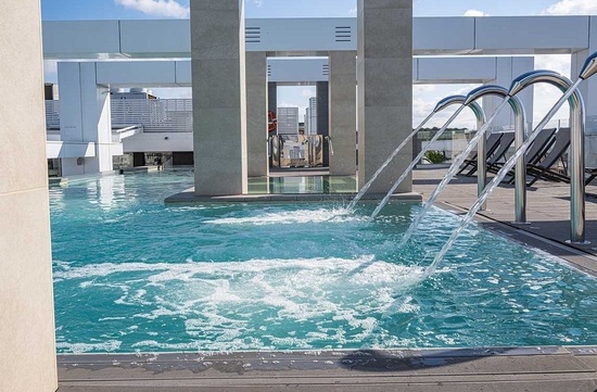 a swimming pool with a fountain in the middle of it