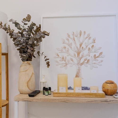 una mesa de madera con velas y botellas de aceites esenciales