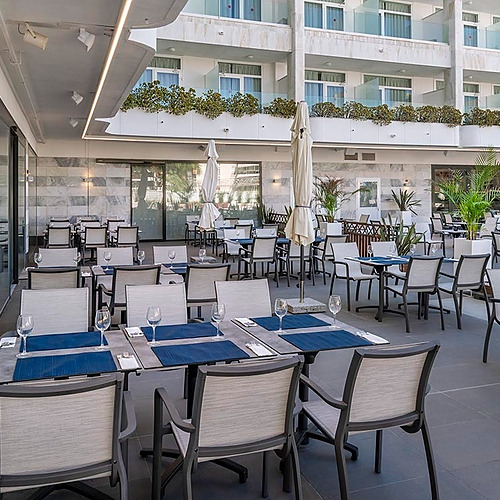 Olympus Palace Hotel Terrasse mit Tischen und Stühlen für Außengastronomie.