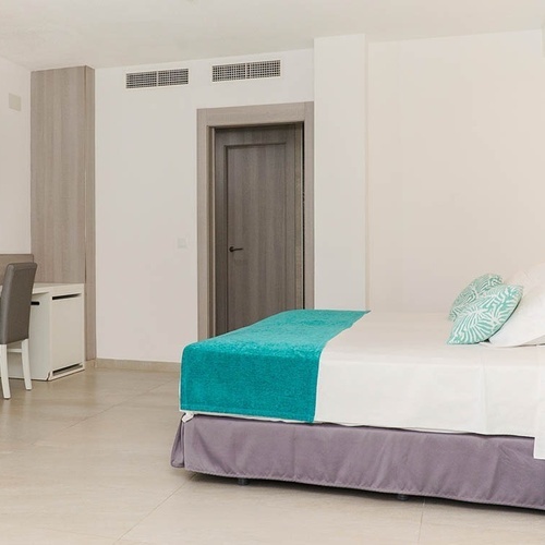 una habitación blanca con una cama y una televisión