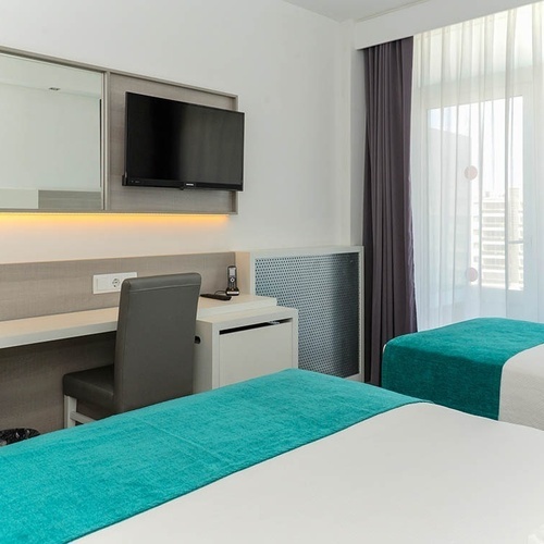 una habitación de hotel con dos camas y una televisión