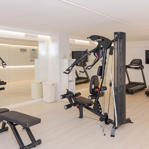 un gimnasio con una máquina de ejercicios y una cinta de correr